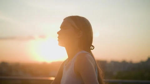 Side View of Young Lady Roller Skating Outdoors at Sunset with Emerald Light Stock Footage 289104678