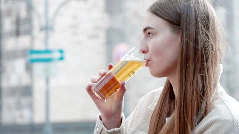 Side view of a young lady sipping fresh beer while traveling alone Stock Footage 203789977