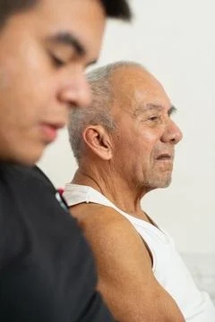 Side view of young man and elderly father sitting together showing calm fam.. Photos