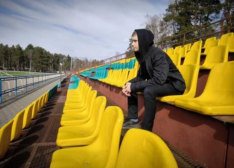 Side view of young man guy resting empty stadium seats Stock Photos