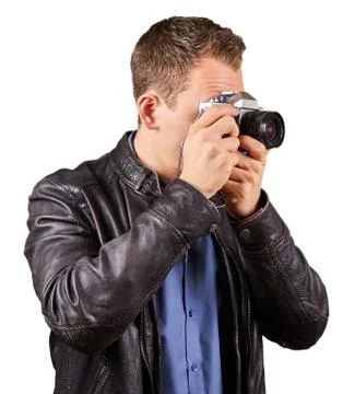 Side view from a young man with a leather jacket holding a vintage camera and Stock Photos
