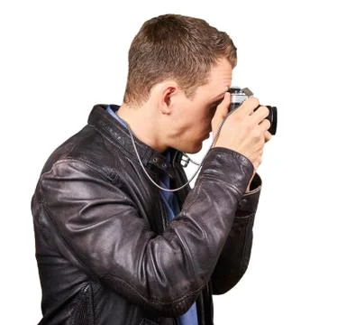 Side view from a young man with a leather jacket holding a vintage camera making Stock Photos