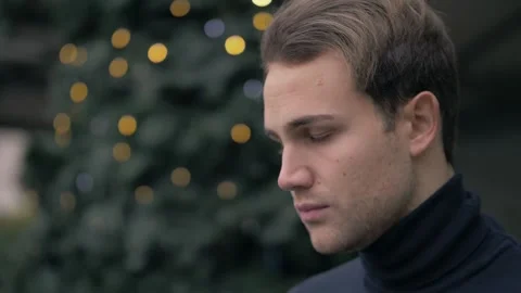 Side View: Young Man Looks Up at the Future with Christmas Lights Behind Him Stock Footage 304973198
