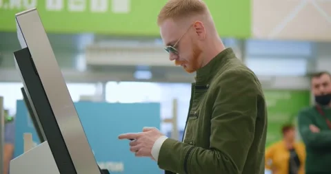 Side view of young man paying at self-checkout using smartphone app at store Stock Footage 136311913