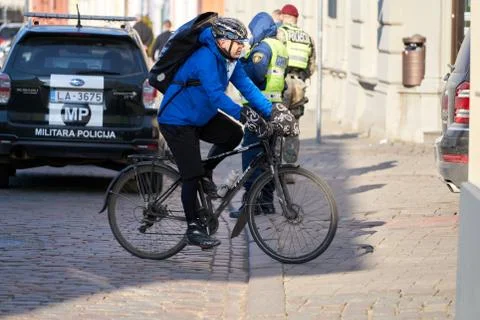 Side view of young man in protective gear with backpack riding bicycle on str Stock Photos