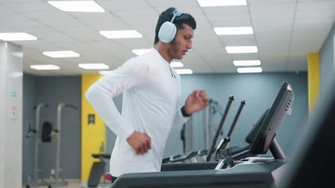 Side view of young man running on treadmill in gym center 스톡 동영상 308328584