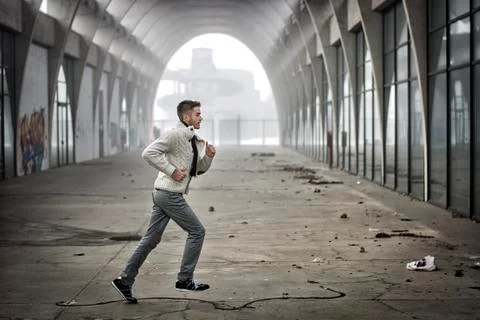 Side View of Young Man Running Through Abandoned Tunnel Stock Photos