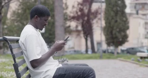 Side view young man texting on smartphone sitting on bench Stock-Footage 333197623