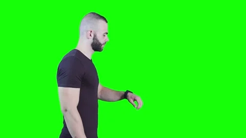 Side view of young man using smartwatch against green background Stock Footage 136369135