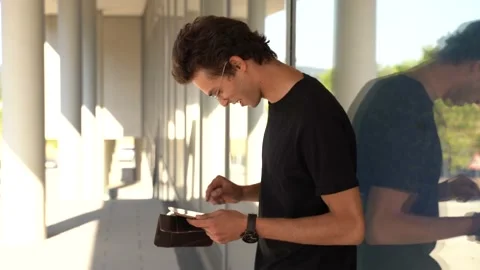 Side view of young man using digital tablet while standing against glass window Stock Footage 136945255