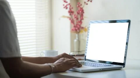 Side view of young man using laptop while sitting in comfortable workplace. Stock Photos