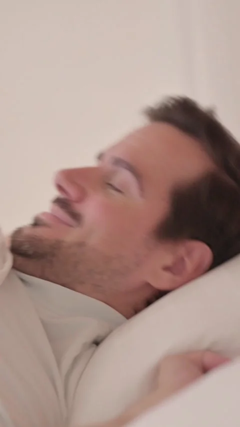 Side View of Young Man Waking Up and Leaving Bed, vertical video Stock Footage 328564999