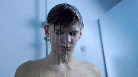 Side view of a young man washing his face under the shower at home. Stock Footage 345531080