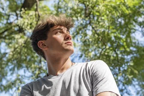Side view of a young man who is looking up over nature background Stock Photos