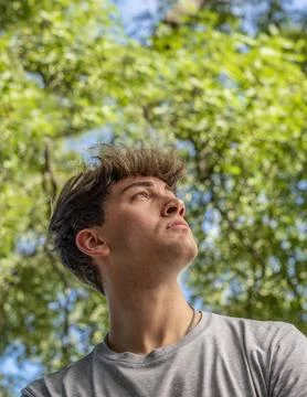 Side view of a young man who is looking up over nature background Stock Photos