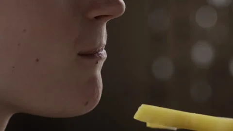 Side view of a young positive caucasian girl taking a bite of yellow bell pepper Stock Footage 143094802