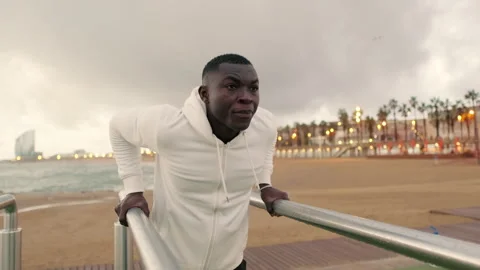 Side view of young strong man doing dips on parallel bars Stock Footage 281504153