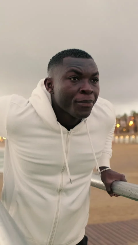 Side view of young strong man doing dips on parallel bars Stock Footage 294080645