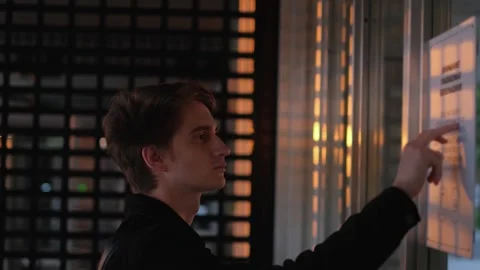 Side view of young student reading notice at university entrance Stock Footage 274991834