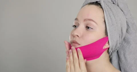 Side view of a young well-groomed european woman wears pink face bandage Stock Footage 151259433
