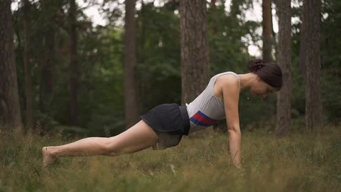 Side view of a young woman doing yoga in the forest Stock Footage 94971925