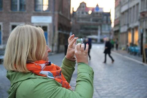 Side view of young woman photographing with cellphone Stock Photos