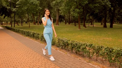 Side view young woman talking by phone on the run Stock Footage 112958114