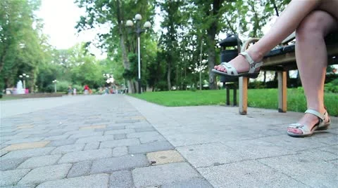 Side view of a young woman using a tablet computer on a park bench.  Stock Footage 21313681