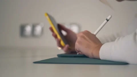 Side view of young woman using mobile phone and digital tablet for lesson onl Stock Footage 143009726