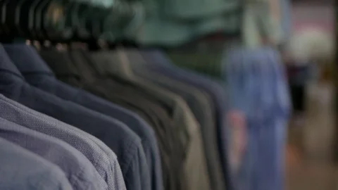 Side view of young woman's hand choosing shirts in store Stock Footage 81644668