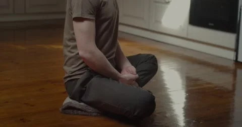 Side view of young yogi sitting in lotus pose meditating alone at kitchen home Stock Footage 151305825