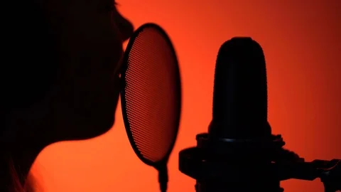 Side view zoom-in close-up shot of cute little girl silhouette singing with a Stock Footage 75198361