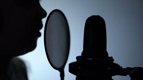 Side view zoom-out close-up shot of cute little girl silhouette singing with a Stock Footage 75197059