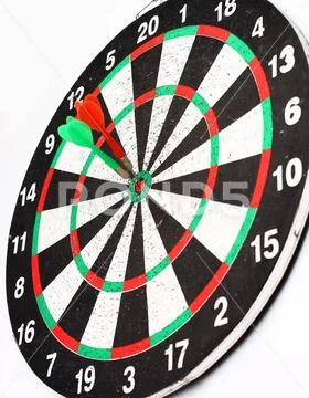 Side view.Arrow dart hitting the center of the target dart Board Stock Photos