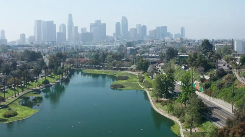 Side ways moving shot of Echo Park Lake and downtown LA buildings towers traffic Stock Footage 273835298