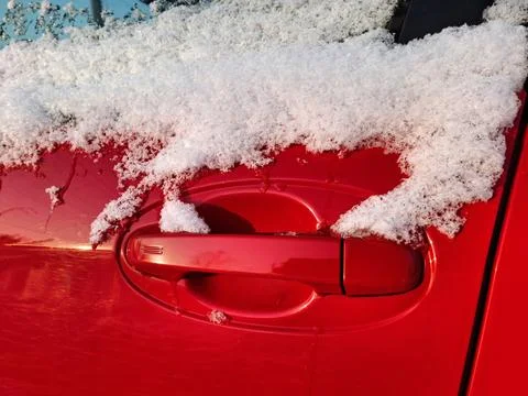 The side window and door handle of the red car are dusted with snow Photos