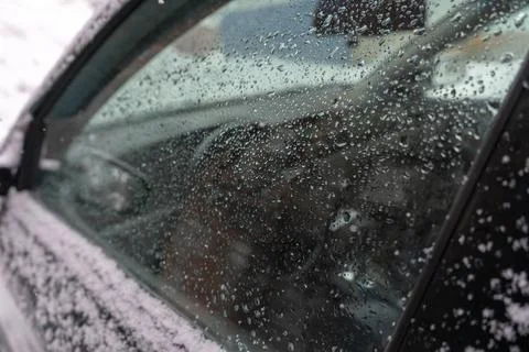 Side window of the car winter drops on the glass snow frozen green Foto stock