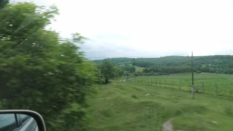 Side Window POV View of Green Hills and Fields from Moving Car Vídeo Stock 338277875