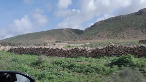 Side Window View Driving Past Green Hills And Village Sidi Ifni Morocco Stock Footage 332773852