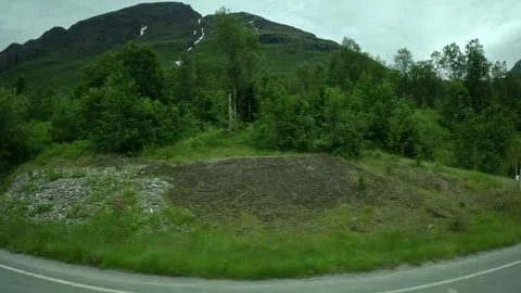 Side window view of small roadside waterfall stream and green mountain in Norway Stock Footage 341272670