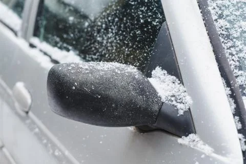 Side windows and rearview mirror of a silver car, powdered with snow Stock Photos