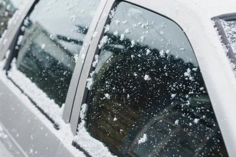 Side windows of silver car powdered with snow on a winter day Stock Photos