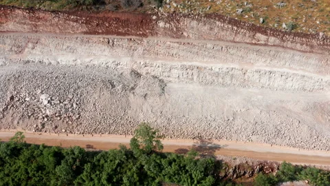 Sidehill cut on the road construction route or quarry. Removing rock and soil Stock Footage 156706587