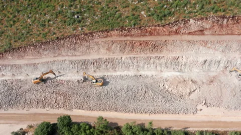 Sidehill cut on the road construction route or quarry. Removing rock and soil Stock Footage 156712446