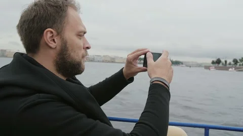Sideview of a handsome man taking photos while sightseeing in St Petersburg Stock Footage 67997937