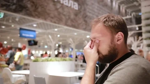 Sideview of a man holding a smartphone in his hand, sitting in a public place Stock Footage 67947895