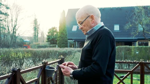 Sideview portrait of senior man using his smart phone while he stands outside Stock Footage 104607684