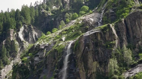 Sideview of a small waterfall makes it's way through the mountain Stock Footage 283564921