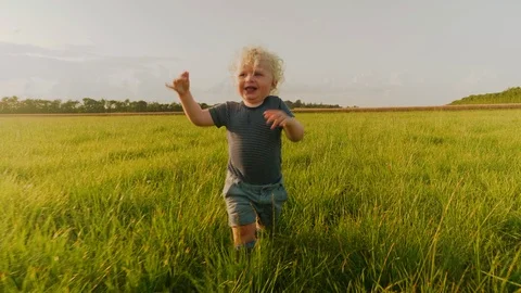 Sideview Tracking Shot of Cute Baby Boy Running and Looking Back at the Camera 스톡 동영상 118128352