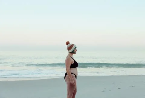 Sideview of a winter bather standing at the beach Stock Photos